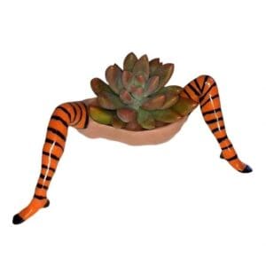 A person with legs and feet painted to look like they are holding a plant.