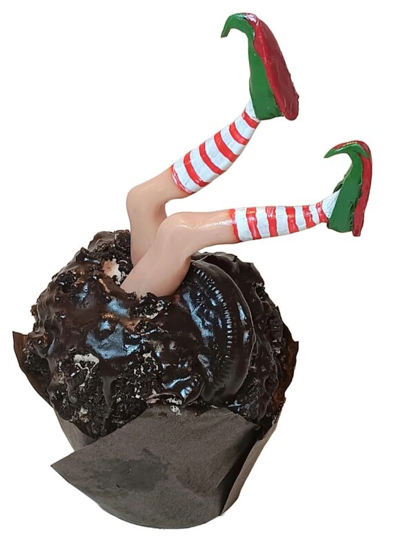 A cupcake with chocolate frosting and elf legs.