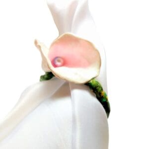 Pink flower napkin ring on white cloth.