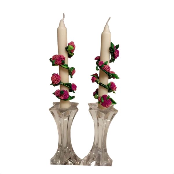 A pair of candles with roses on them