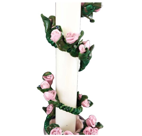 A candle with pink roses on it