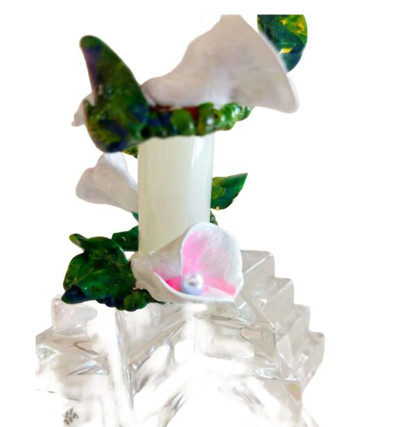 A candle with flowers on top of it.