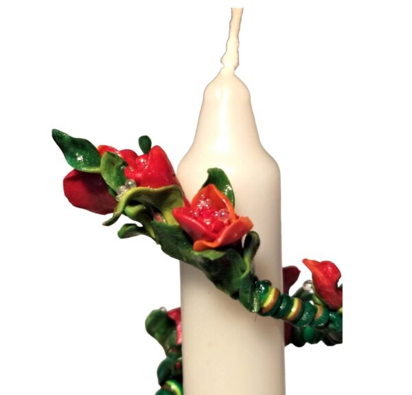 A candle with red roses on it