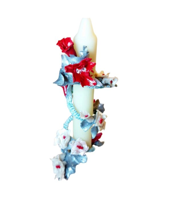 A candle with flowers on it is hanging from the side.