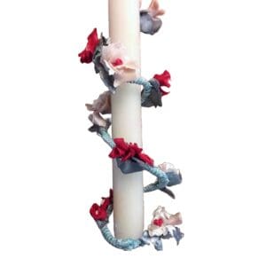 A candle with red and blue flowers on it.