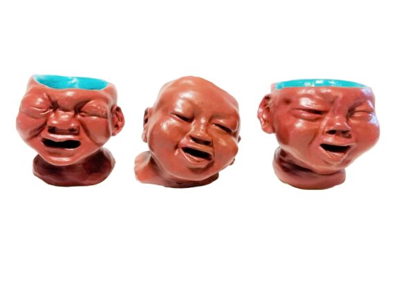 Three ceramic heads are lined up in a row.
