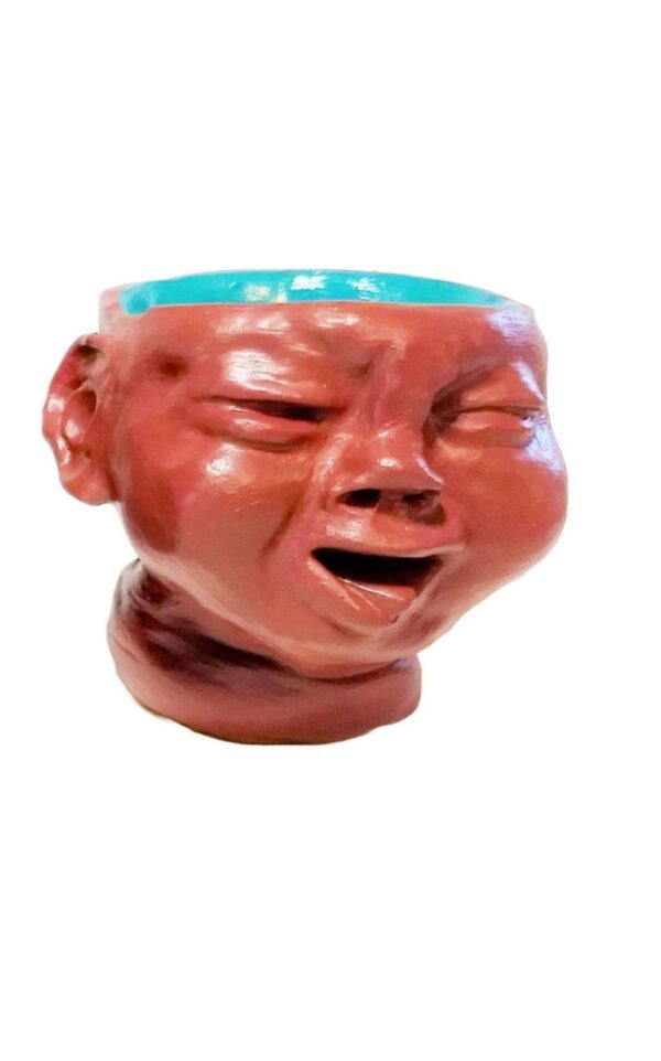 A ceramic head with a blue bowl in it's mouth.