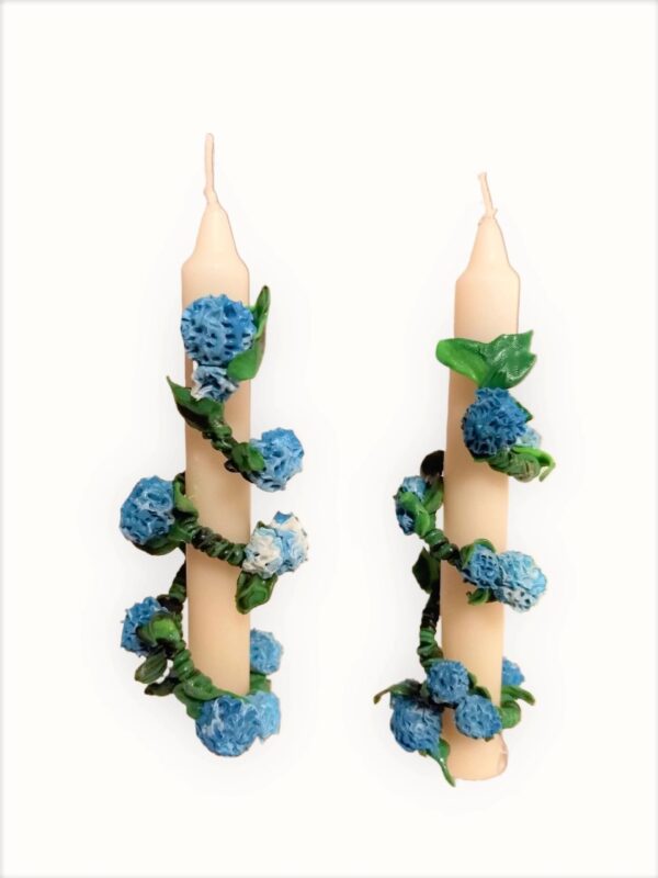 Two candles with blue flowers on them