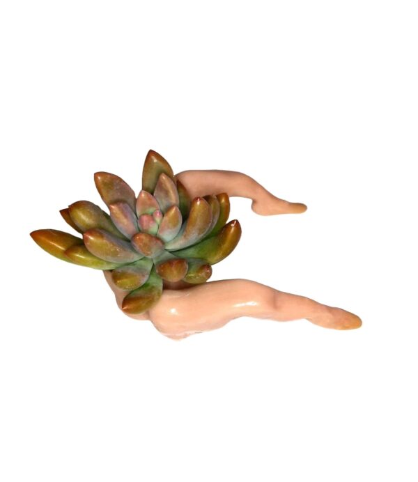 A ceramic sculpture of a woman with a plant in her hand.