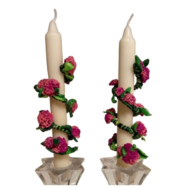 A pair of candles with roses on them.