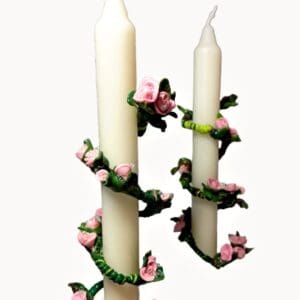 A pair of candles with pink flowers on them.