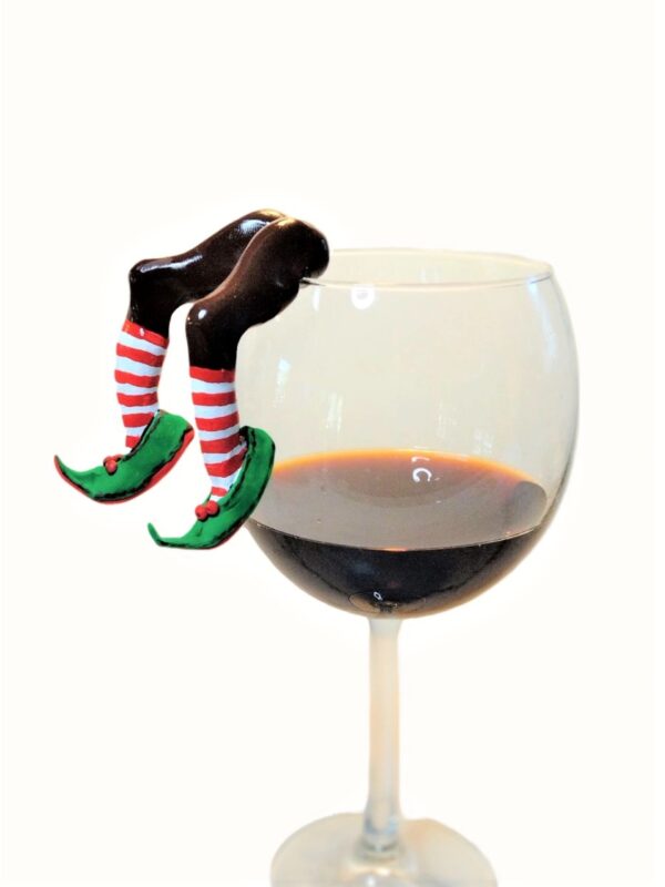 A glass of wine with two legs sticking out of it.