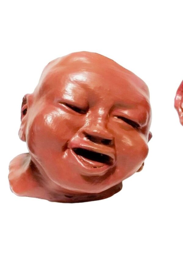 A ceramic head of an infant with his mouth open.