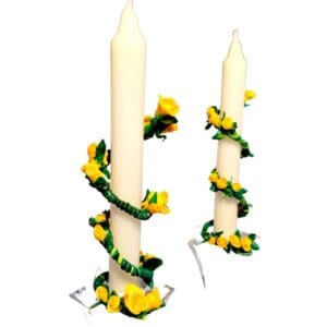 A pair of candles with yellow flowers on them.