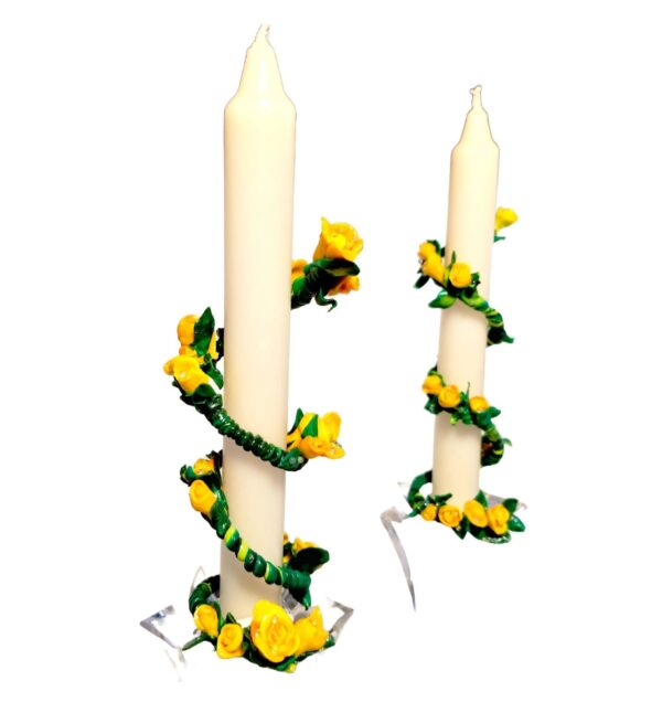 A pair of candles with yellow flowers on them.
