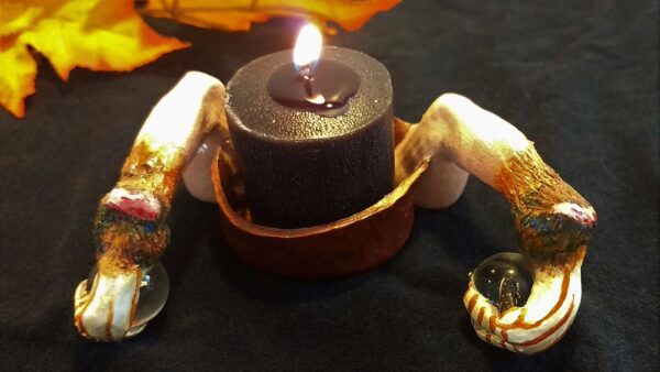 A candle is lit on the table with two hands.