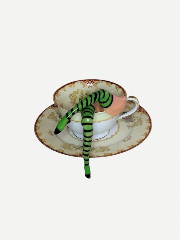 A cup and saucer with a snake on it.