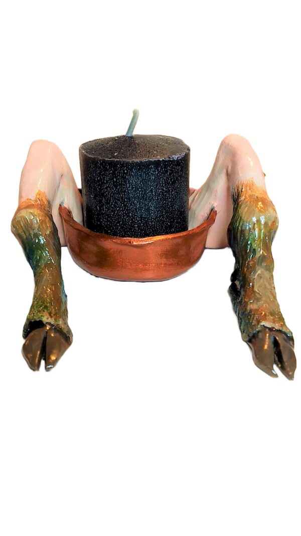 A close up of a candle holder with arms and legs