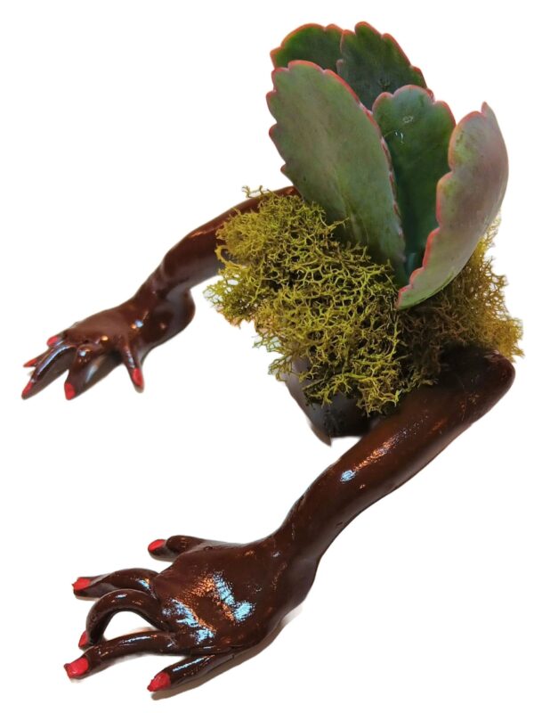 A sculpture of a hand holding a plant