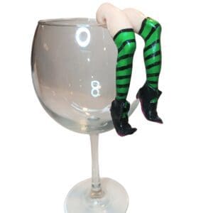 A glass of wine with a woman 's legs hanging over the top.