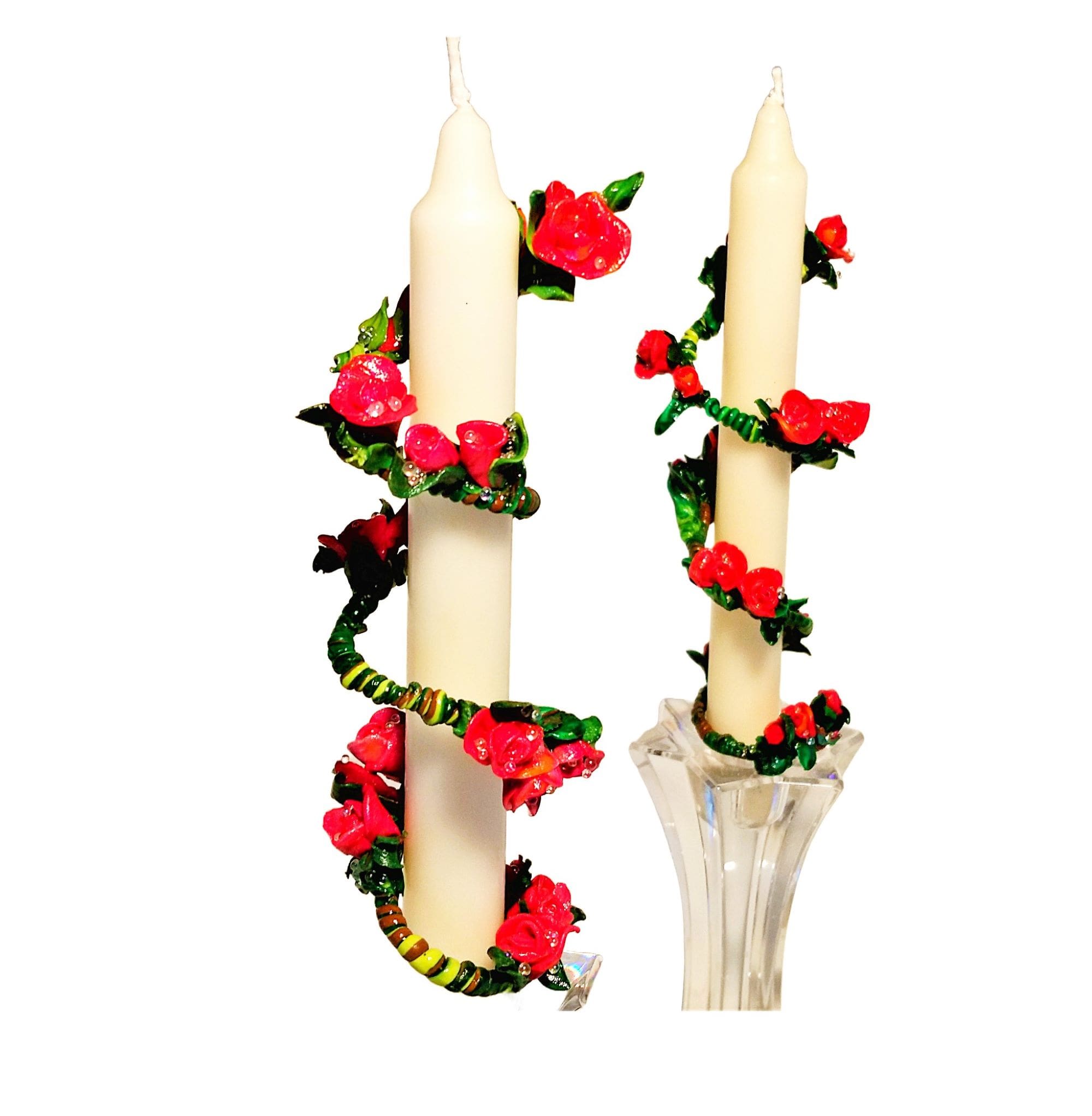 White candles with red floral decorations.