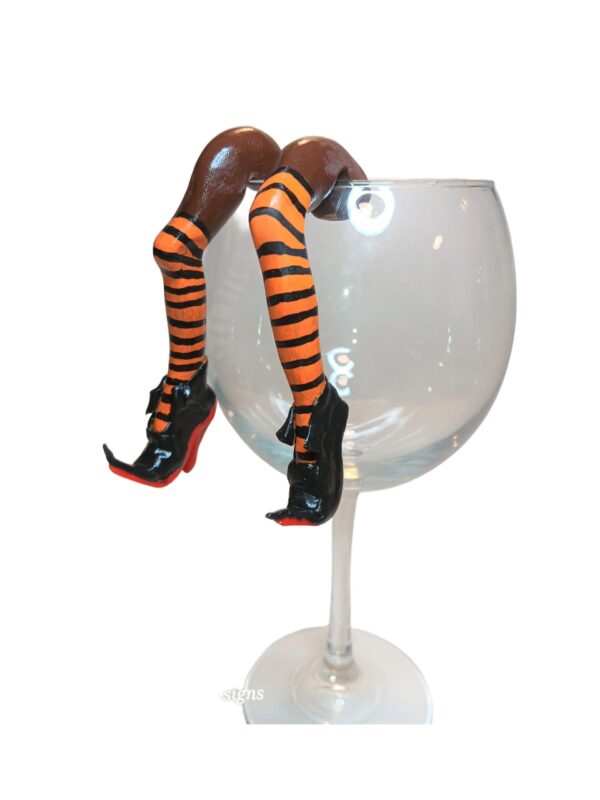 A glass of wine with legs and shoes on it