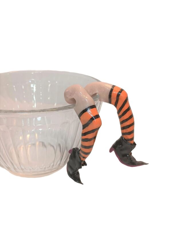 A glass bowl with legs and stockings on it.