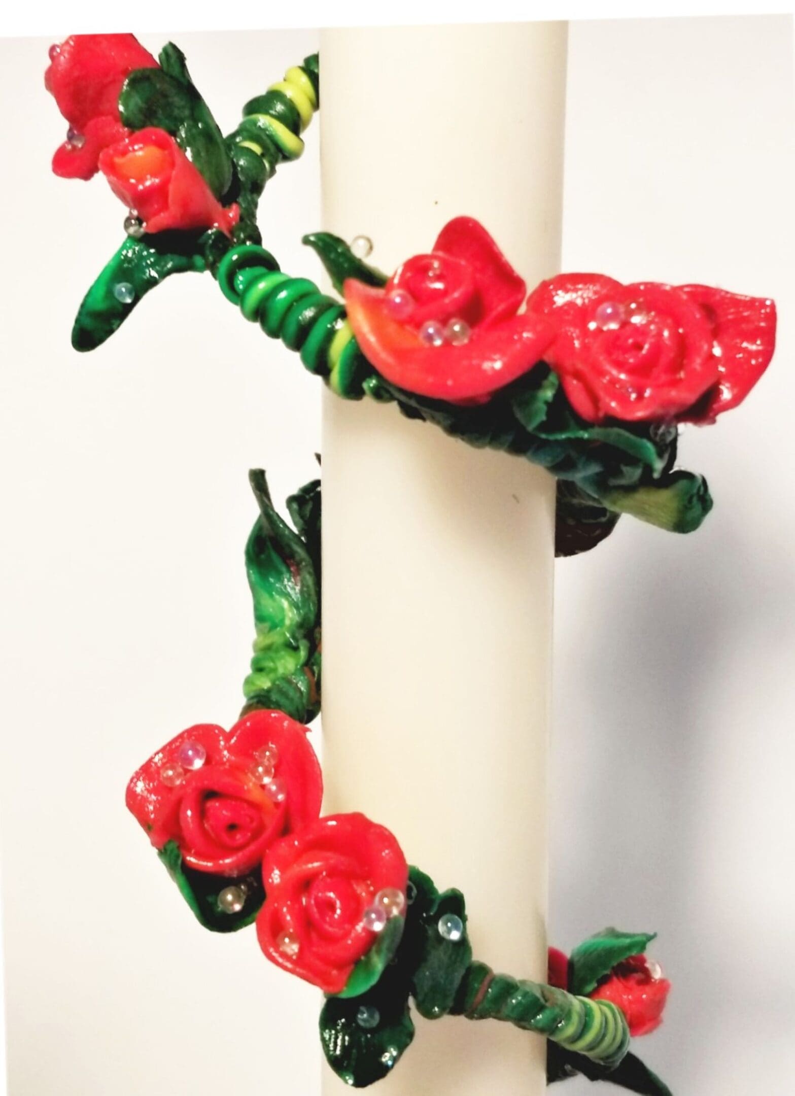 Red roses wrapped around a white cylinder.